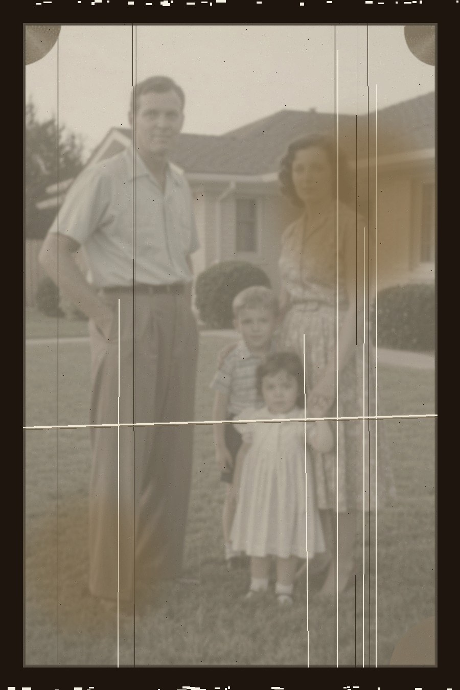 Damaged 1950s American family photograph before restoration, showing scratches, fading, stains and blur